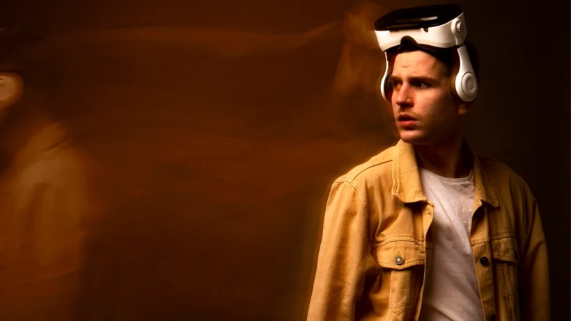 A man wearing a futuristic VR headset looking thoughtful, symbolizing the uncertainty and human reflection surrounding the AI bubble and technology trends in 2025.